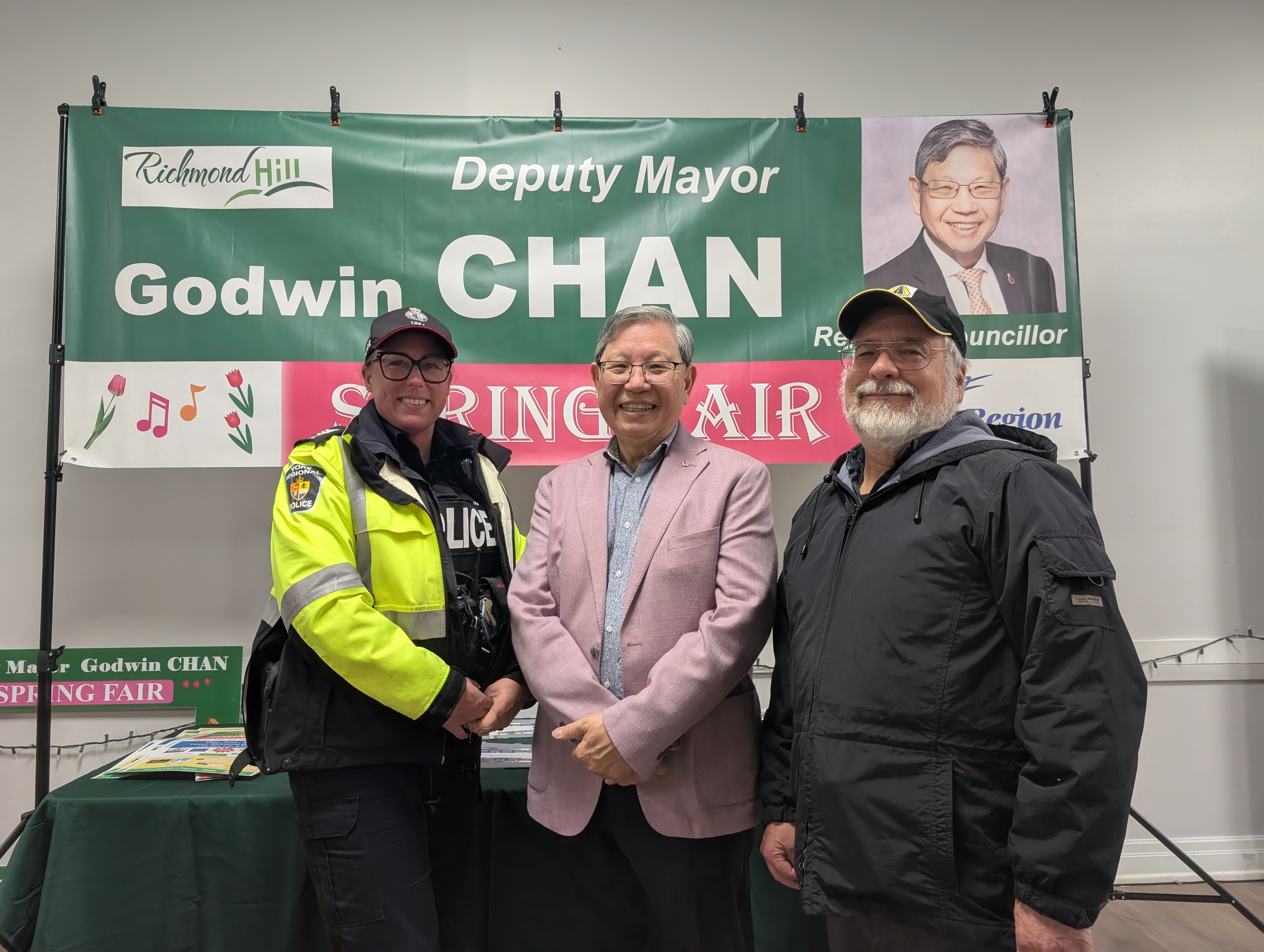 Marty Paulin standing with Deputy Mayor Godwin Chan and a York Regional Police officer at a news conference banner