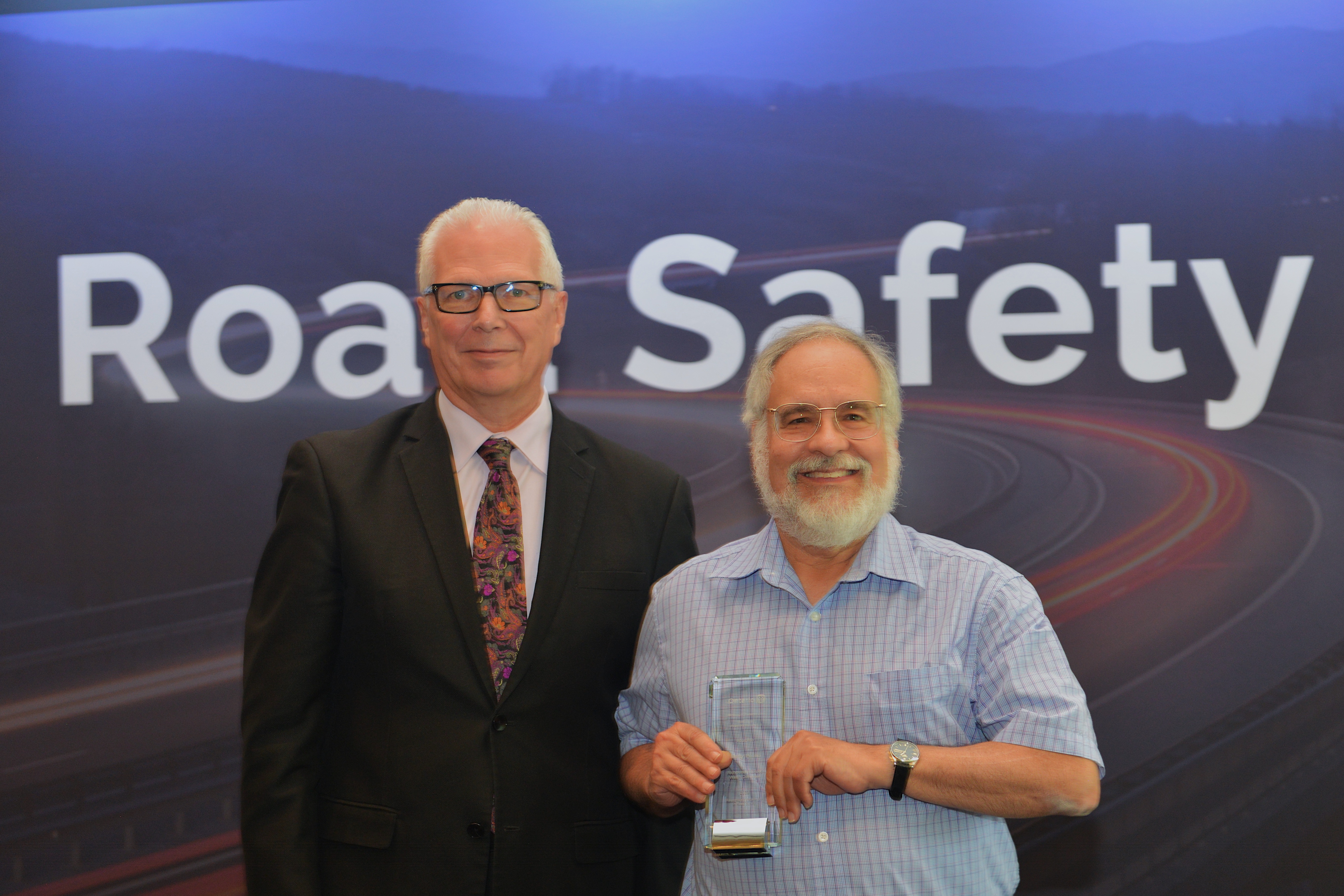 Marty Paulin holding the 2023 Road Safety Award next to an official