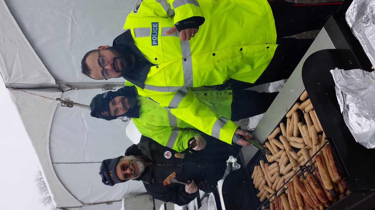Marty Paulin cooking pancakes with York Regional Police officers at the Winter Carnival